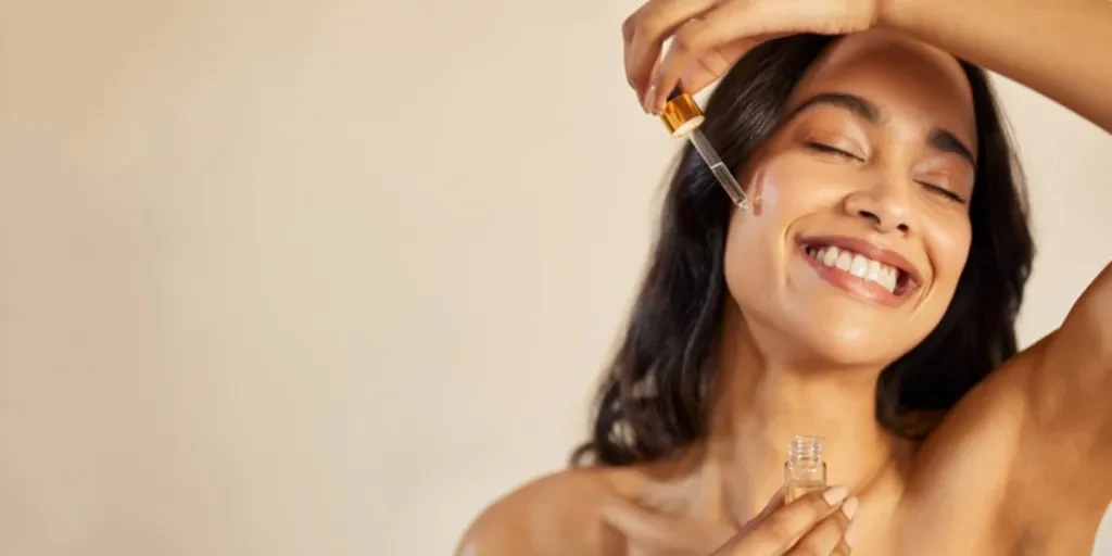 A woman applying glycolic acid serum on her face