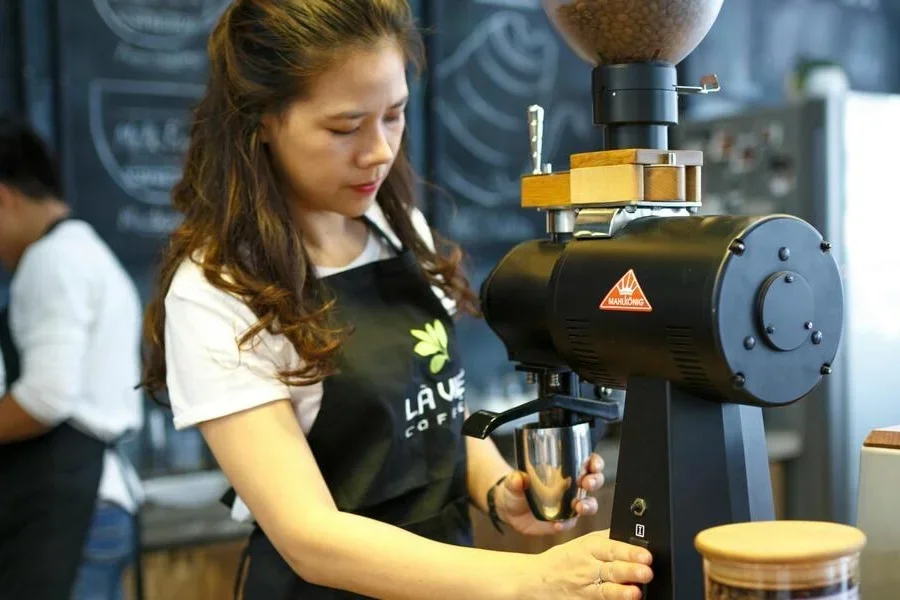 A woman grinding coffee beans