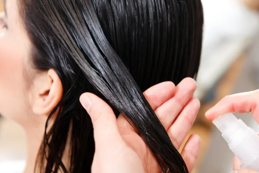 A woman is getting her hair sprayed