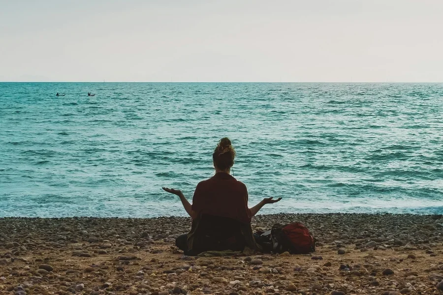 Женщина медитирует на пляже