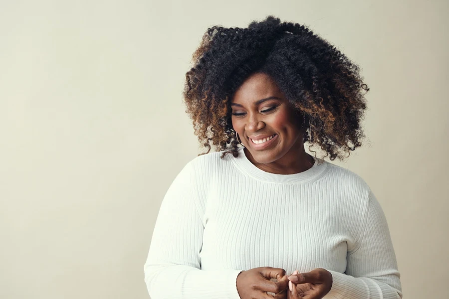 A woman with a short curly cut and highlights