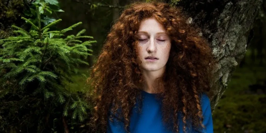 A woman with curly hair in a blue shirt