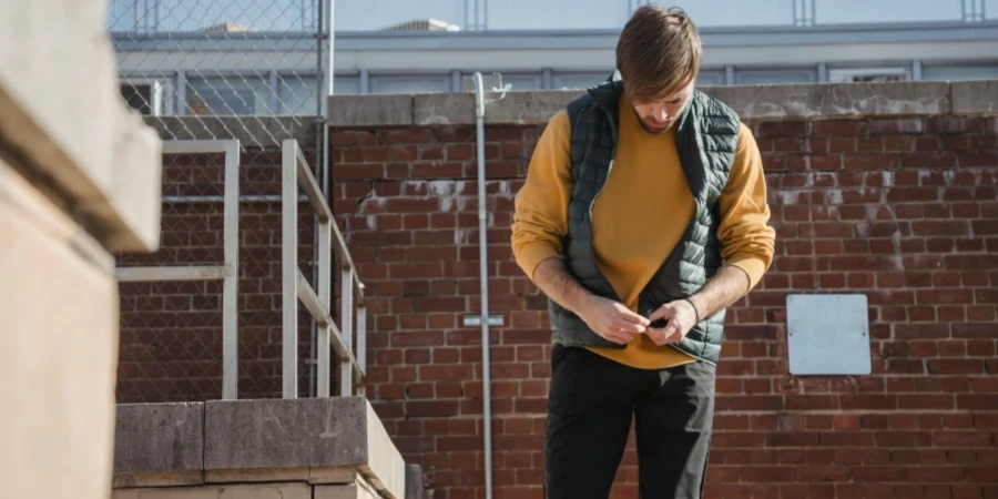 A young man in casual attire relaxes on a rooftop, exuding a calm and modern vibe