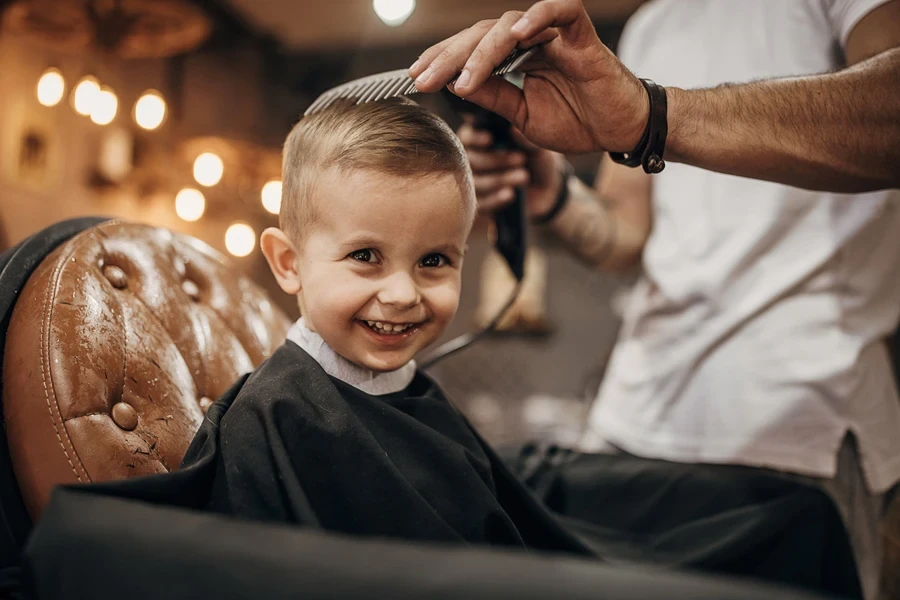 Barber drying young boys freshly cut short hair