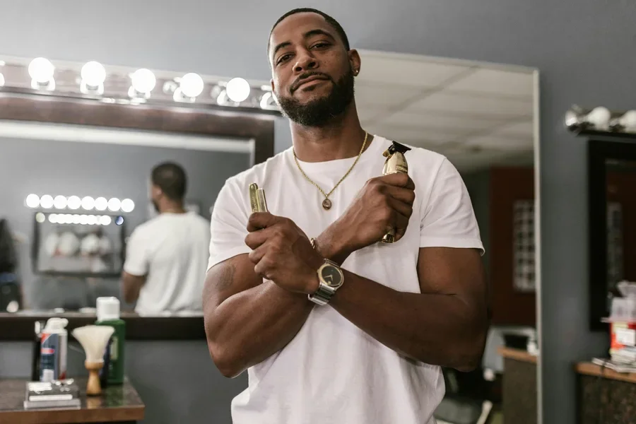 Barbero en una elegante tienda sosteniendo unas tijeras con una pose segura, listo para trabajar