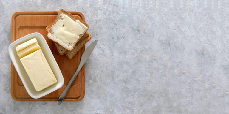 Bloc de beurre dans un beurrier avec du pain grillé à côté