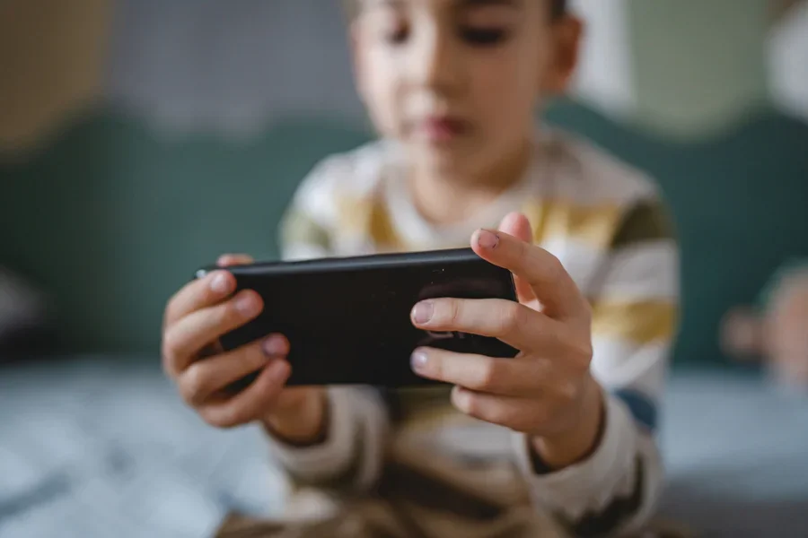 Boy playing with a portable gaming monitor