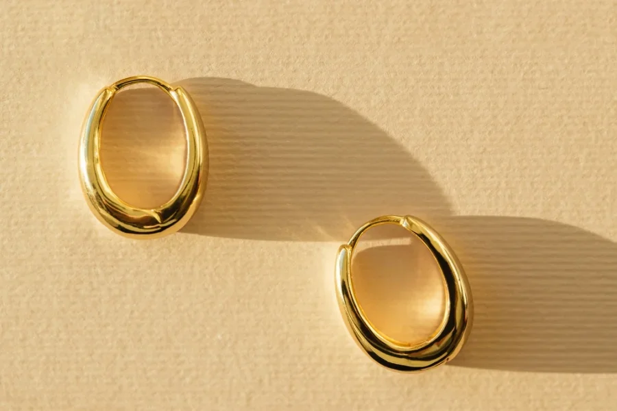 Créoles épaisses en or sur fond jaune pastel