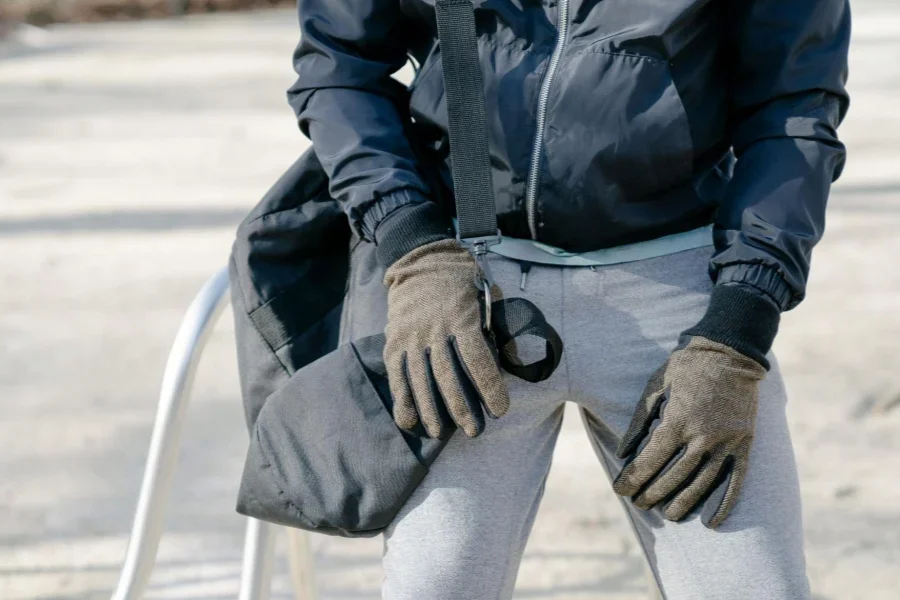 Crop Person in warmer Kleidung mit Tasche auf der Straße