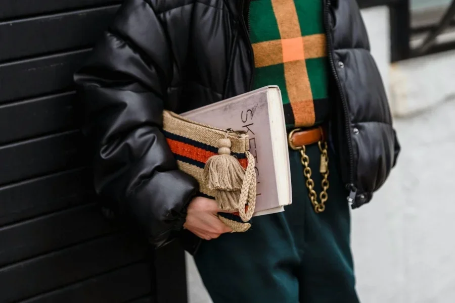 Estudiante de moda con cuaderno y bolso en la calle