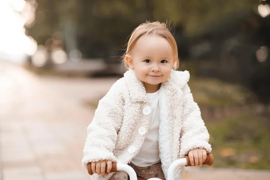 Linda niña montando bicicleta de equilibrio