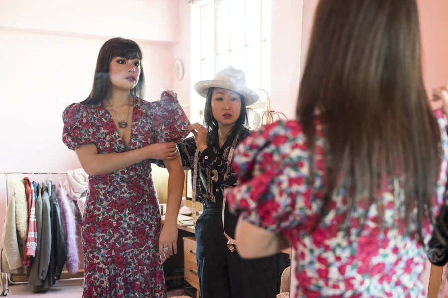 Designer styling a model in a puff-sleeve flowery dress