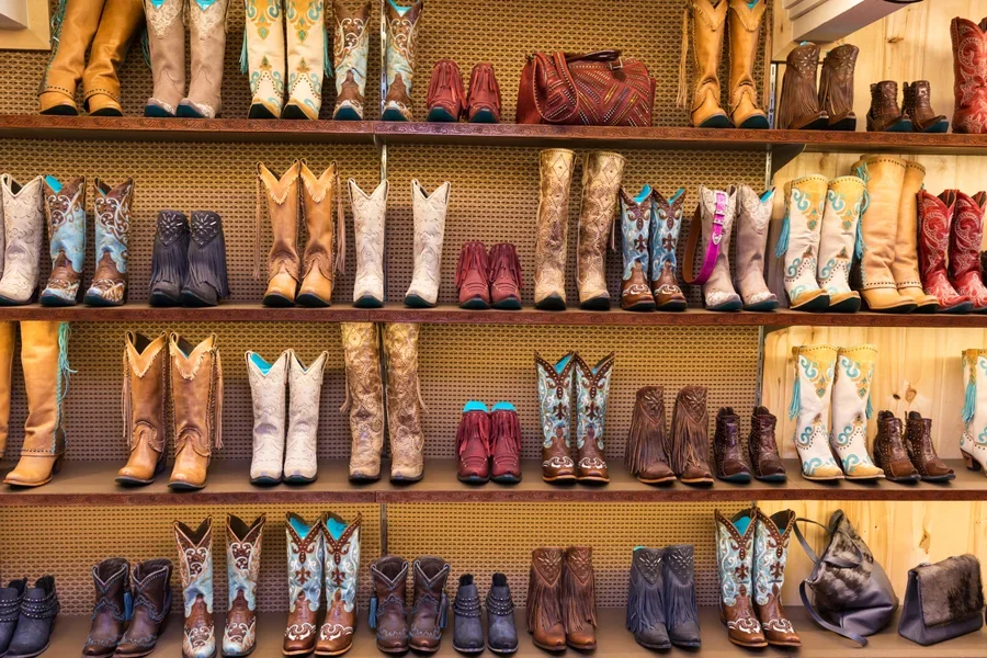 Diferentes tipos de botas de vaquero en un estante de una tienda.
