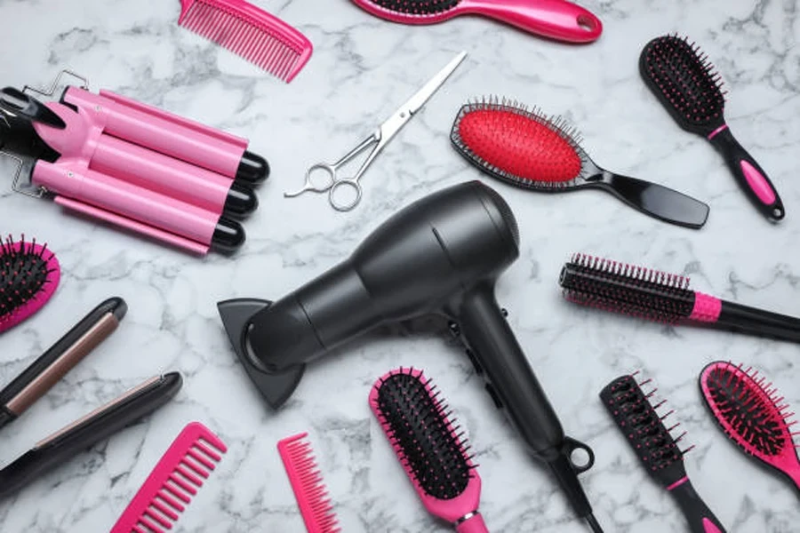 Flat lay composition of different professional hairdresser tools on white marble table