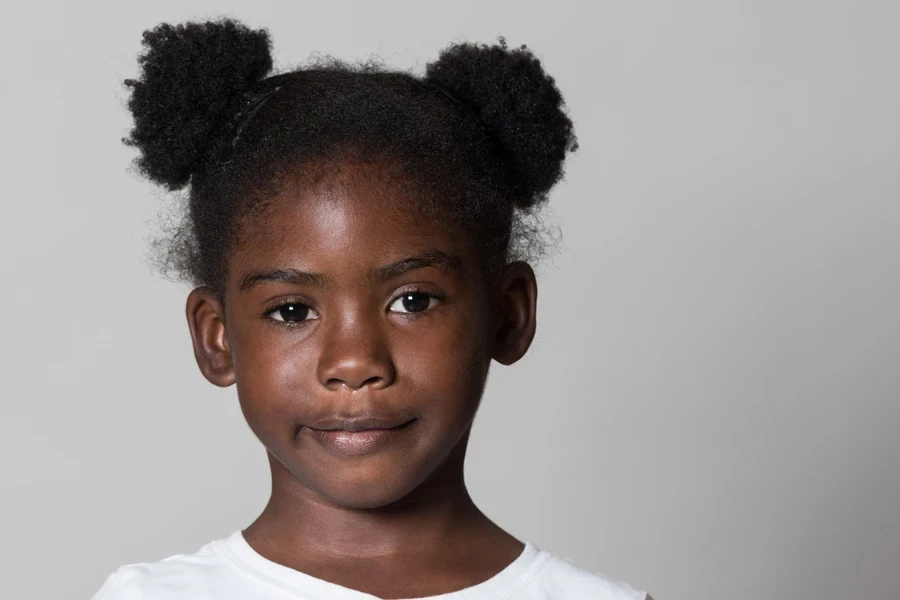 Girl with dark skin wearing double space buns on head
