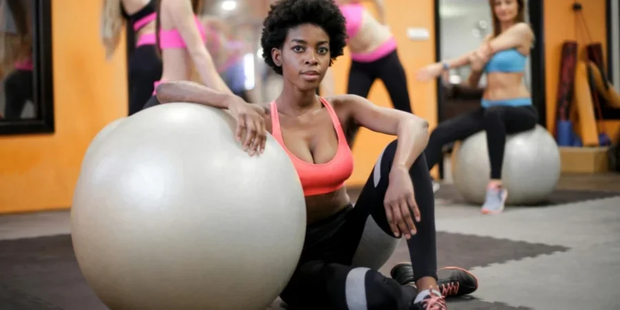 Grupo de mujeres haciendo ejercicio con pelotas de fitness en un gimnasio moderno