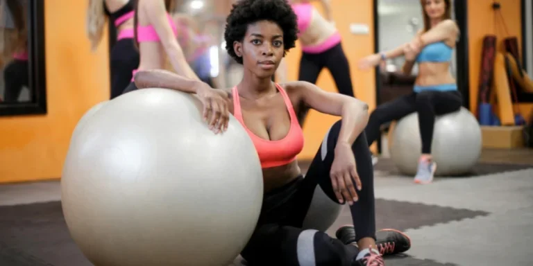 Grupo de mujeres haciendo ejercicio con pelotas de fitness en un gimnasio moderno