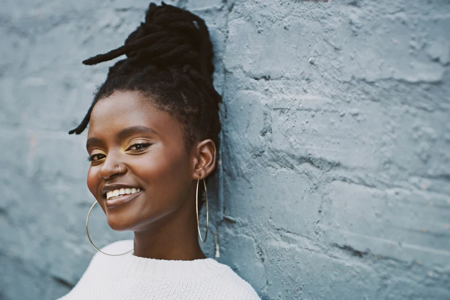 Happy girl with dreadlocks in a bun