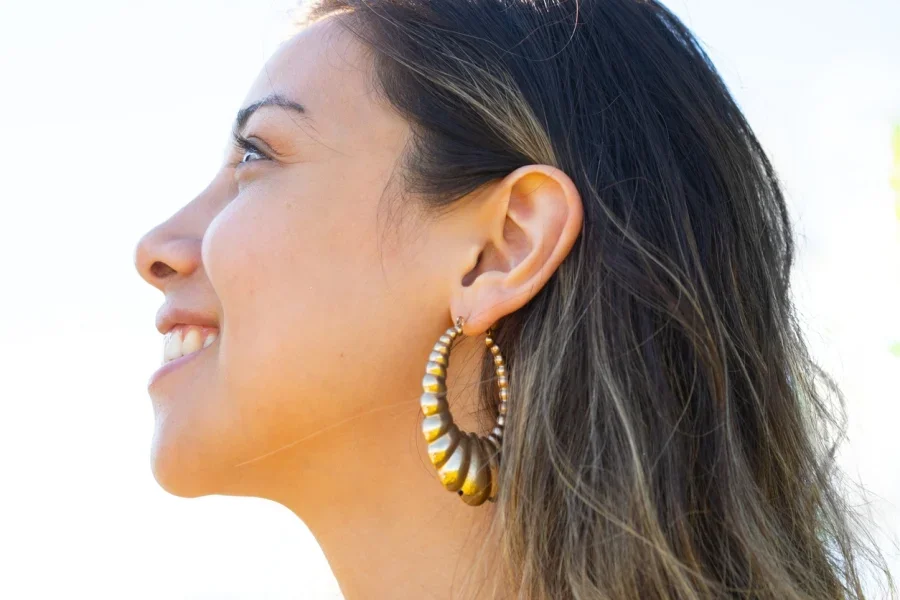 Femme heureuse portant des boucles d'oreilles épaisses et côtelées