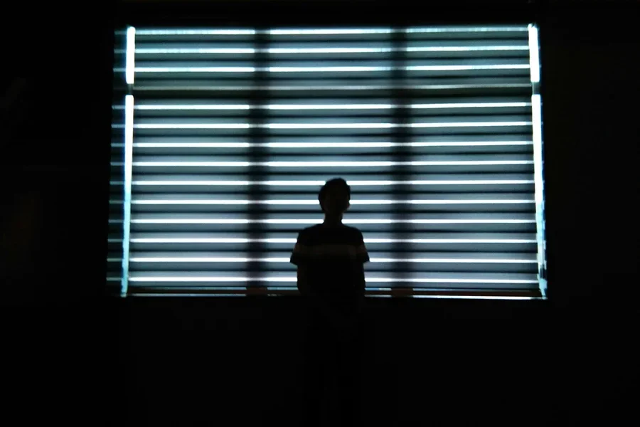 Man adjusting blinds using a remote control