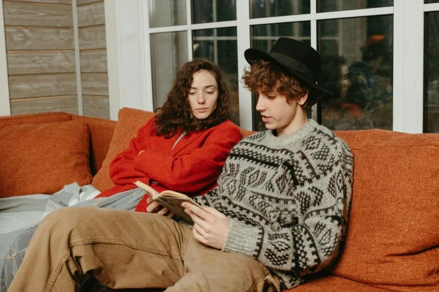 Man and Woman Sitting on Orange Sofa