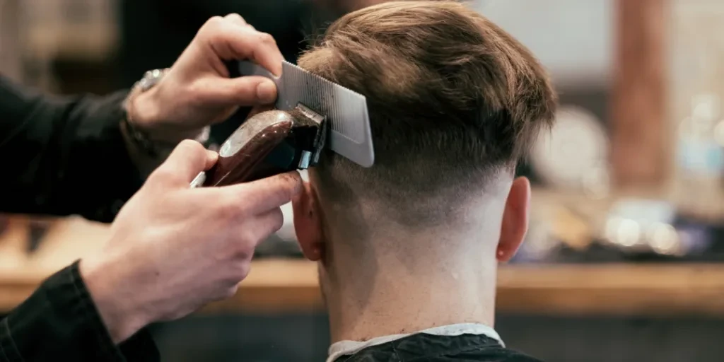 Man at barber shop getting mid drop fade haircut