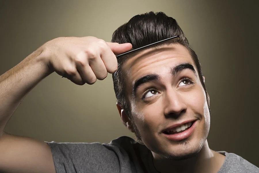 Man combing his quiff backward for a sleek look