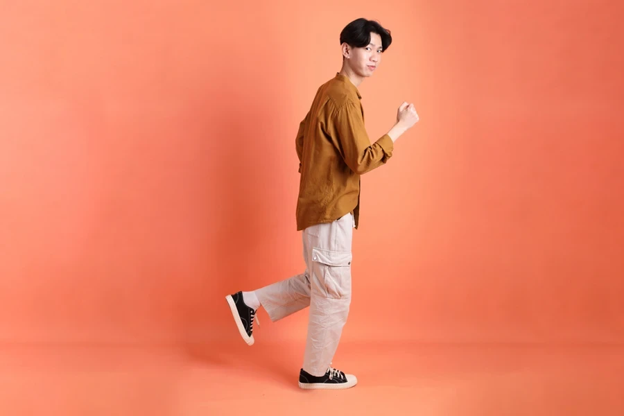 Man posing in white cargo pants with large pockets