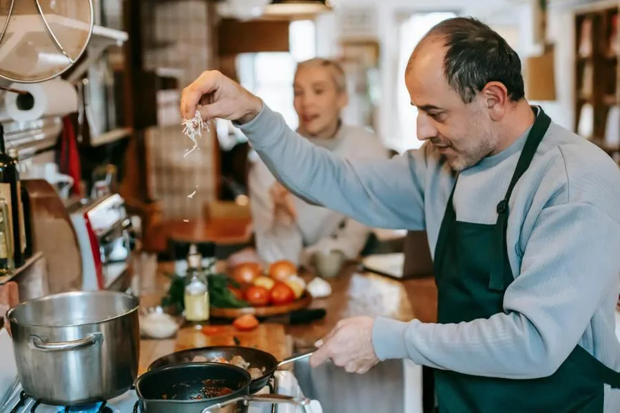 コンロで料理を準備する男性
