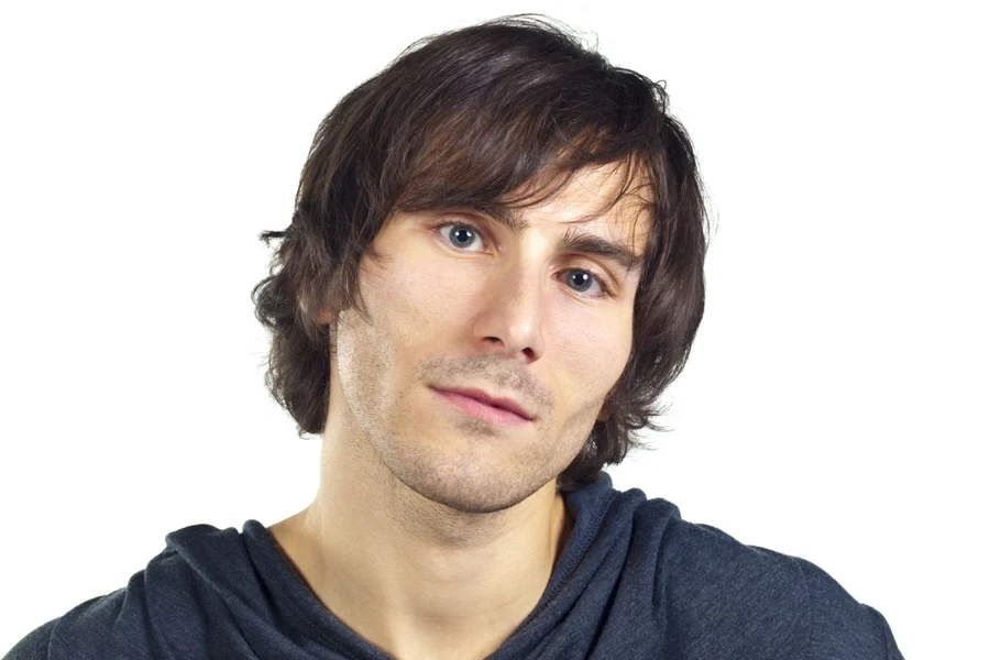 Man styling mod cut while wearing dark blue sweater