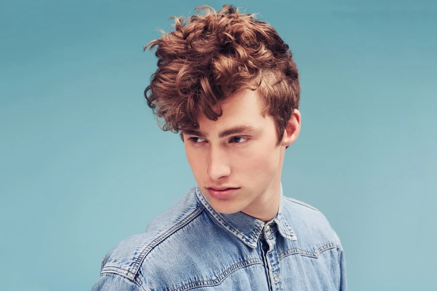 Man with brown hair that’s styled in a messy fringe