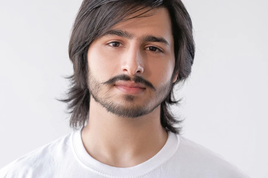 Man with facial hair sporting wispy mod haircut