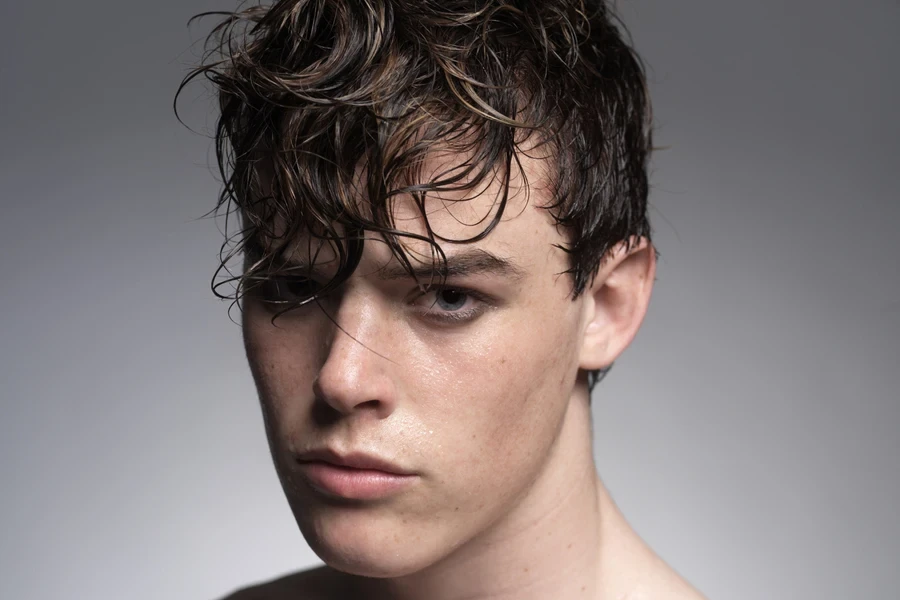 Man with wet, tousled hair and long textured fringe