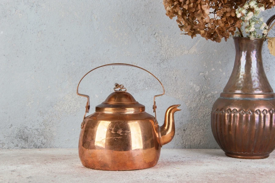 Modern copper kettle with brass handle on countertop