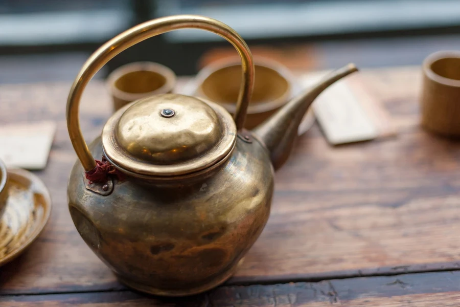 Old copper kettle with long, thin spout and lid