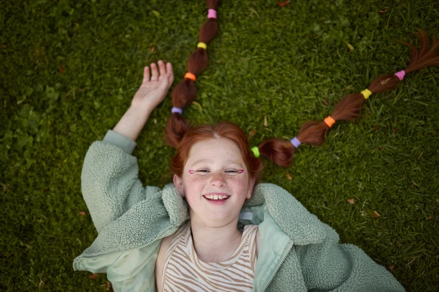 Older child with thick hair sporting colorful cute braids