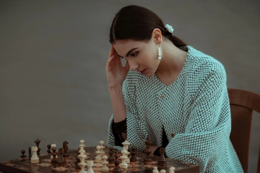 Pensive ethnic woman thinking on chess move