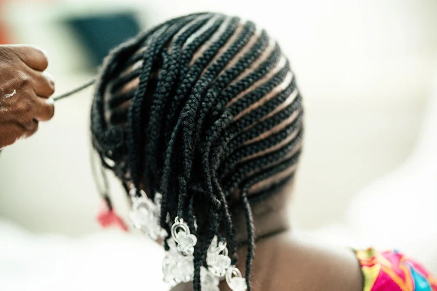 Person braiding a young woman