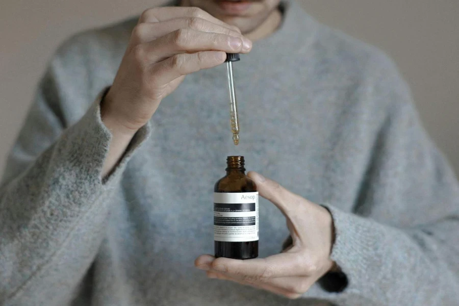 Person holding a glycolic acid serum dropper