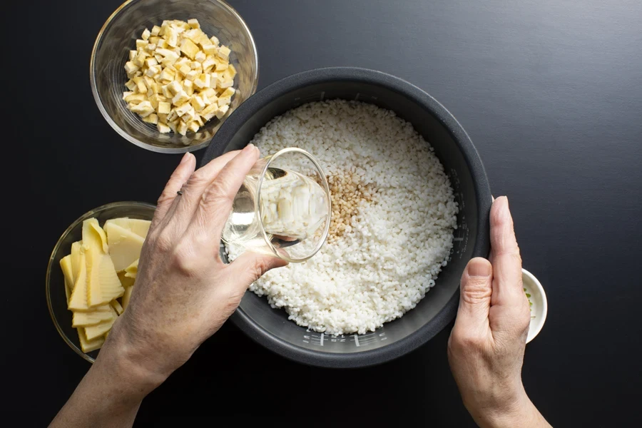Person pouring water into rice cooker