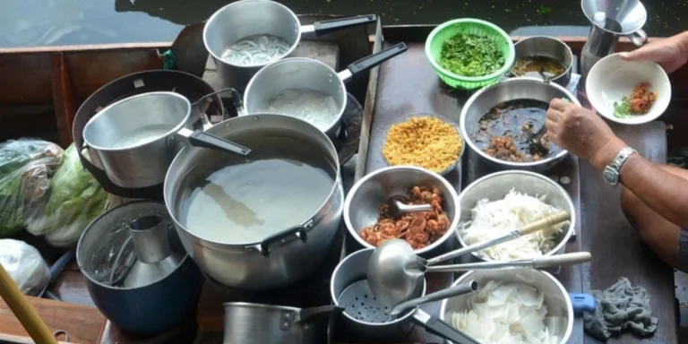 Person preparing food with different pots and pans on boat