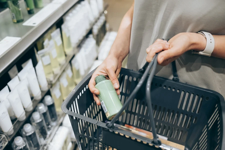 Person shopping for hair care products with small basket