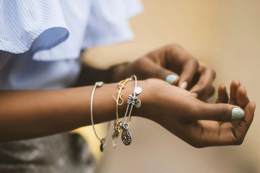 Selective Focus Photography of Person Wearing Three Bangles