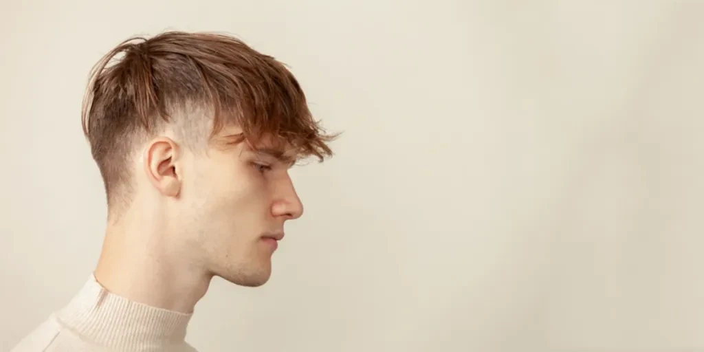 Side profile of young man with textured fringe haircut