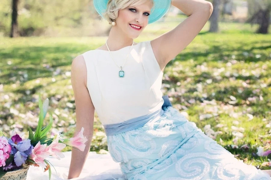Smiling woman sitting next to a basket with flowers