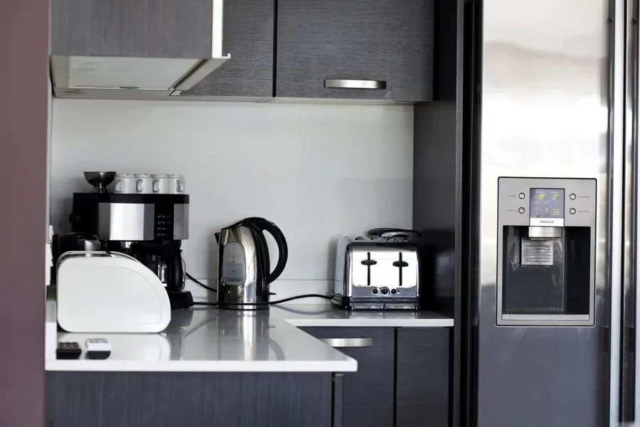 The image displays an electric micro-oven containing bread, likely mid-toast, with a warm glow emanating from within.