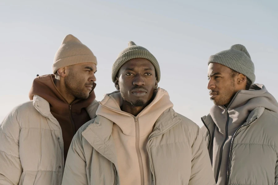 Three men in stylish winter attire showcasing modern fashion trends outdoors