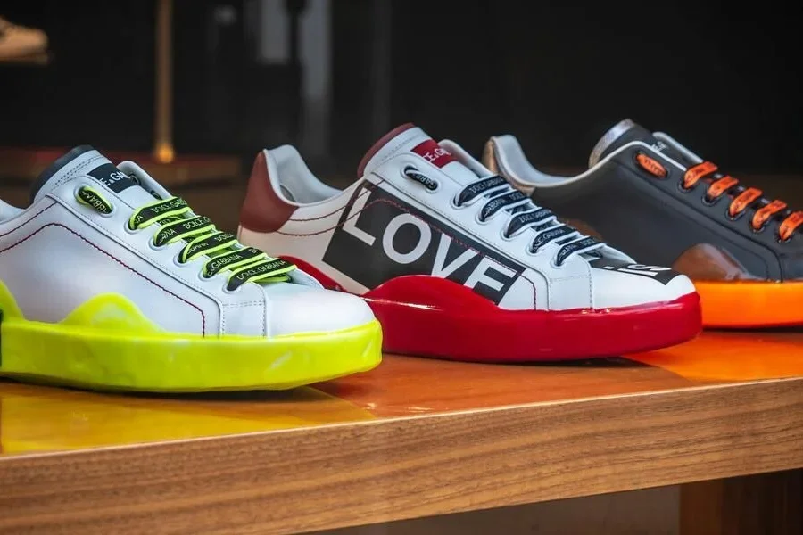 Три разноцветных кроссовка на деревянной поверхности