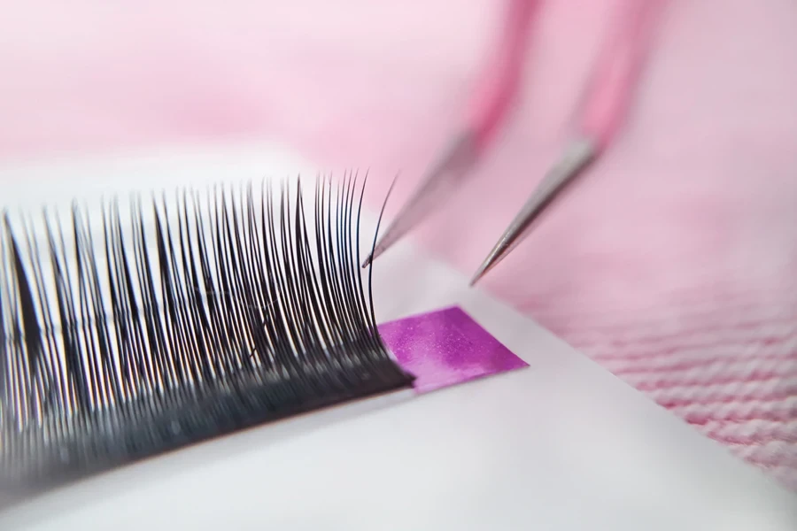 Tweezers about to pick a light-volume lash cluster