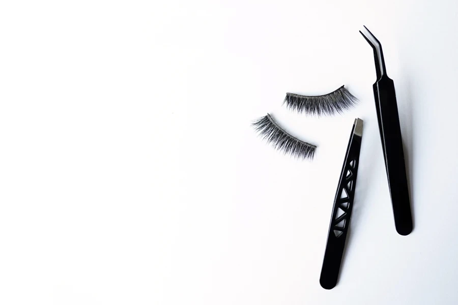 Two lash clusters with eyelash tools on a white background
